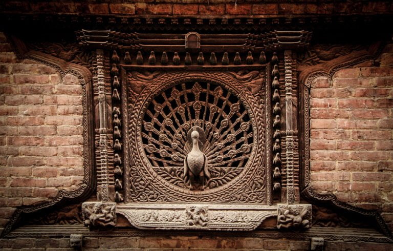Intricately carved traditional wooden window with a peacock design on a brick wall.