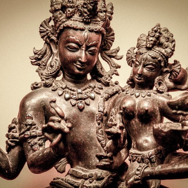 An antique bronze statue of Hindu deities with multiple arms in intricate poses and detailed adornments.