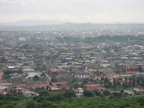 A sprawling cityscape with dense housing and buildings under an overcast sky.