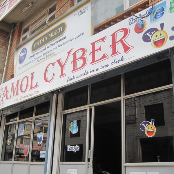 A storefront with several social media and internet browser logos, including Facebook, Twitter, Yahoo, and Google, on the sign and windows with the name "MOL CYBER" prominently displayed.