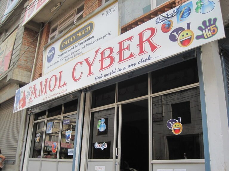 A storefront with several social media and internet browser logos, including Facebook, Twitter, Yahoo, and Google, on the sign and windows with the name "MOL CYBER" prominently displayed.