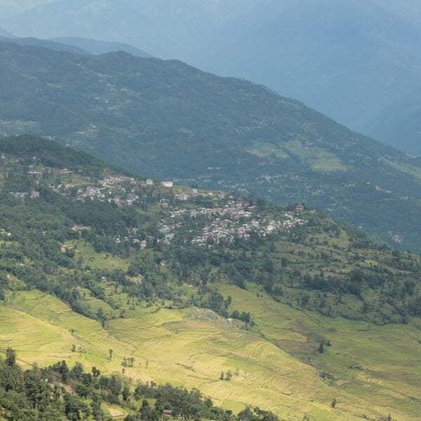 Aerial view of a terraced landscape with a small town nestled among green, rolling hills.