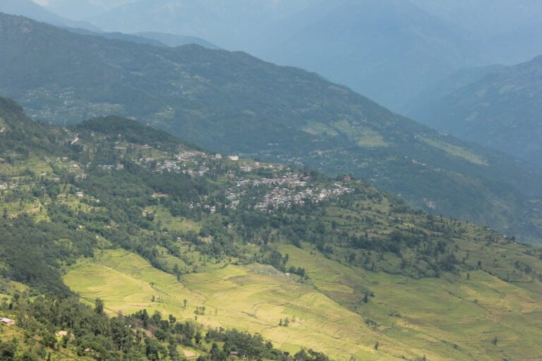 Aerial view of a terraced landscape with a small town nestled among green, rolling hills.