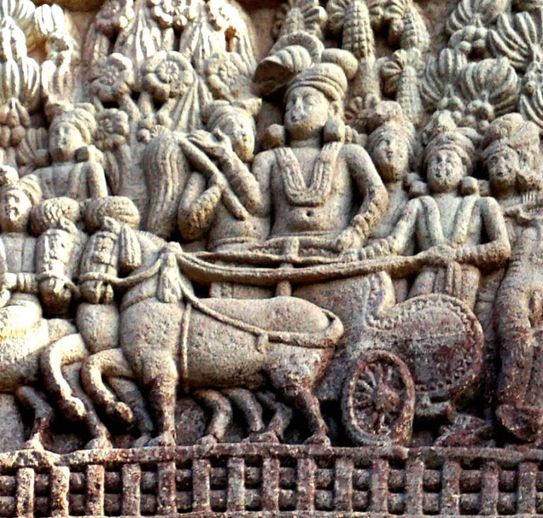 Ancient stone relief depicting a chariot pulled by horses, surrounded by various figures, some appearing to be in conversation, and intricate foliage patterns above.