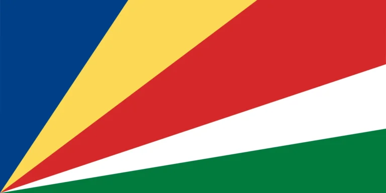 The image displays a flag with diagonally divided fields of blue, yellow, red, and green, from the left upper corner to the lower right corner, with a thin white stripe separating the red and green sections.