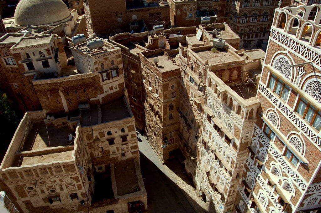 Aerial view of densely packed traditional Yemeni houses with elaborate, multi-patterned facades in Sana'a, Yemen.