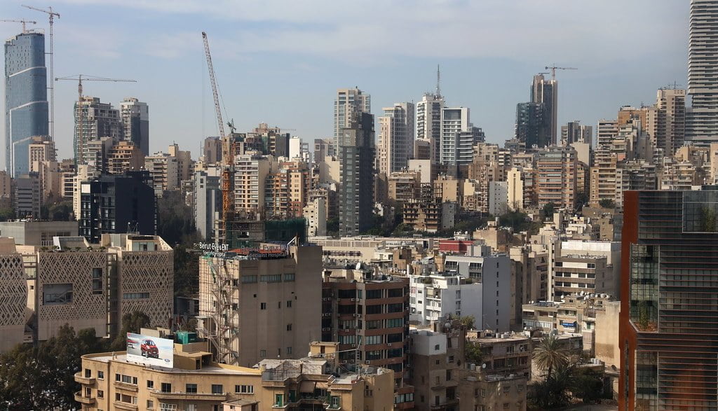 A panoramic view of a dense cityscape with various high-rise buildings under construction, interspersed with completed residential and commercial towers.