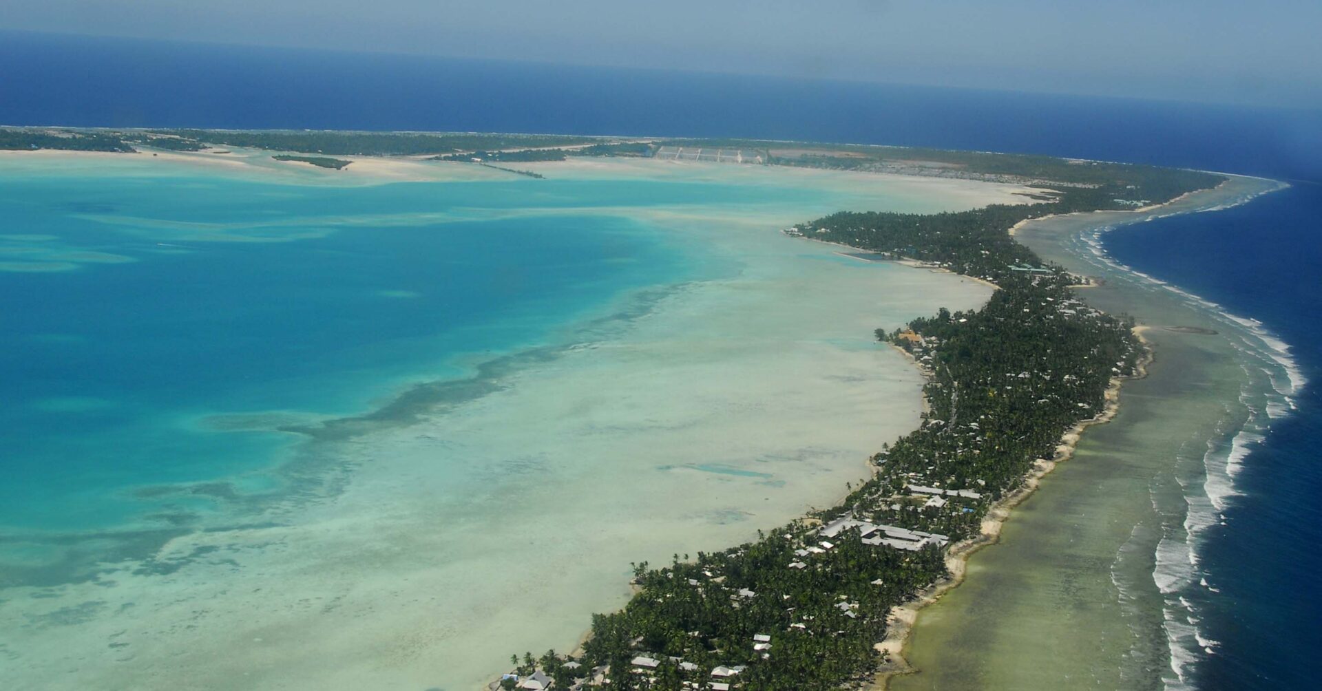 Aerial view of a tropical coastline with turquoise waters, sandy beaches, and lush greenery.